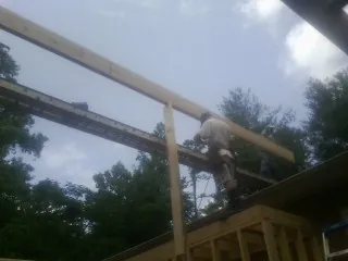 Carpenter setting a ridge beam over a new addition frame — Ice Dam Removal by Roofing Brothers in Hagerstown